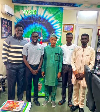 Five men pose together in an office, standing in front of a vibrant green and blue tie-dye banner that reads "Web3 Lagos," while they discuss the adoption of blockchain technology with the Honorable Commissioner for Culture and Tourism, Hon. Dr. Sesan Fagbaye.