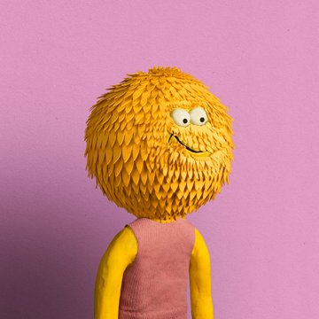 The image features a cartoon character with a large head, wearing a pink shirt and yellow leaves attached to its face. The character appears to be smiling, giving off a cheerful vibe. The background of the image is purple, which contrasts nicely with the bright colors of the character's outfit. There are no texts or other objects in the image, making it a simple yet visually appealing composition that highlights the cartoon character and its unique features.