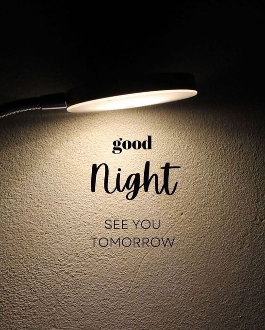 A desk lamp casts a warm glow on a textured wall, illuminating the text "Good Night - SEE YOU TOMORROW" in elegant script and bold lettering. The image serves as a fitting visual for the post's message of resting after a productive day and looking forward to continued progress with @moovexyz.