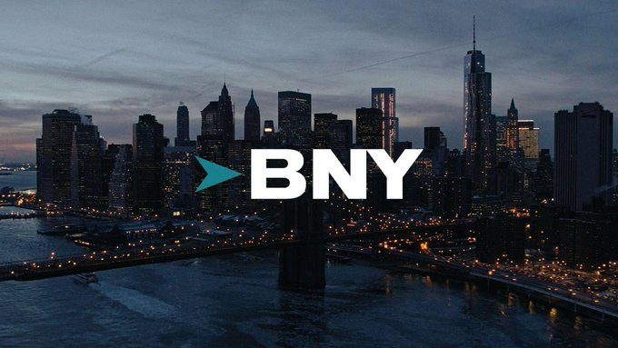 The image shows a dusk cityscape with a prominent "BNY" logo (the Bank of New York's branding with its teal arrow symbol) overlaid on a skyline featuring the One World Trade Center and a bridge, visually tying the post about BNY partnering with Galaxy to offer institutional crypto custody and staking services to the bank's corporate identity.