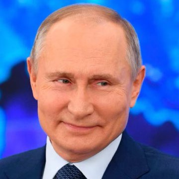 Vladimir Putin smiles during a broadcast, set against a blue-toned backdrop. The image connects to the post highlighting Russia's push to prioritize a regulated crypto market, contrasting with U.S. legislative delays on the CLARITY Act.
