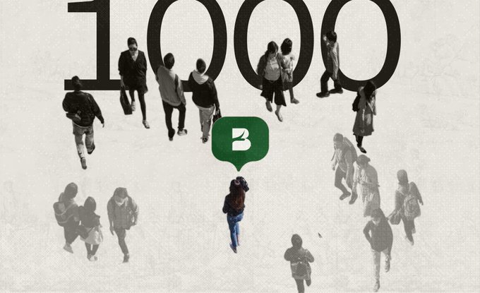 The image features a large group of people walking around with backpacks and handbags. The main focus of the image is a person standing out from the crowd by holding up a green speech bubble that says "b3". This individual seems to be the center of attention, as they are surrounded by other people who appear to be following them or going in different directions. The background of the image is white with black text and numbers, which could possibly represent some sort of data or information related to the post.