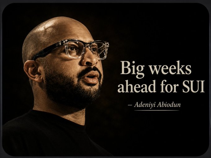 A bald man with glasses and a beard looks into the distance against a dark background, alongside the quote "Big weeks ahead for SUI — Adeniyi Abiodun." The image, attributed to Adeniyi Abiodun, accompanies news of Sui Network's mainnet achieving a record 2.5 million TPS milestone.