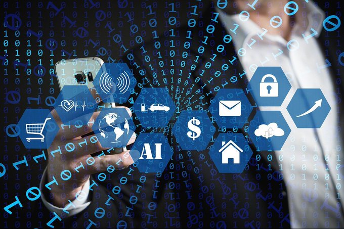 A businessman interacts with a smartphone surrounded by floating digital icons—including "AI," a padlock, dollar sign, globe, and shopping cart—against a backdrop of binary code, symbolizing the convergence of technology and finance. The imagery of icons like the dollar sign and "AI," set within streams of code, visually captures the post's theme of digital assets and automated financial systems operating as an autonomous, self-moving structure.