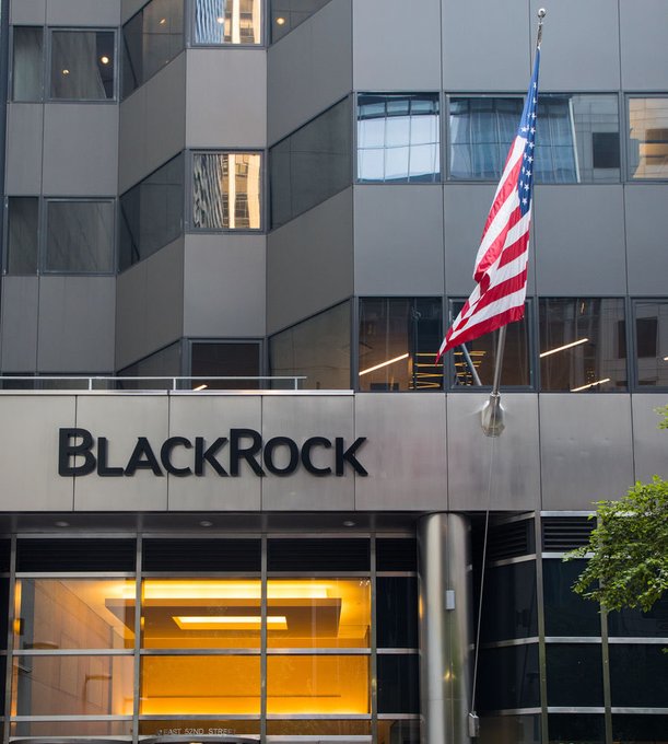 The exterior of a building featuring a 'BLACKROCK' sign, an American flag, and a lit entrance.