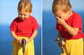A young boy in a red shirt and yellow shorts holds a damaged black flip phone, covering his face in the second image as if mourning the device. The image captures a child's exaggerated grief, matching the post's eulogy for his beloved "Mac" phone.