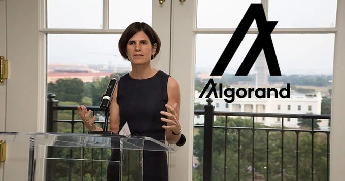 A woman speaks at a podium in front of a window with the Algorand logo overlayed, suggesting a connection to the @AlgoFoundation's past operations.