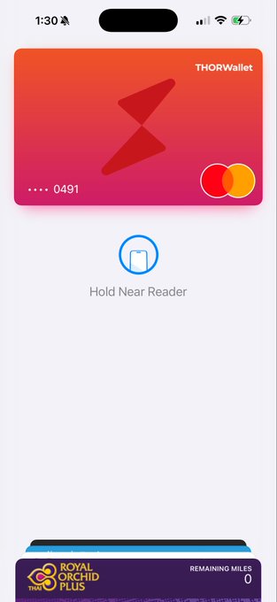 The image shows an iPhone screen displaying a mobile payment app called THOR wallet Card. The app allows users to make contactless payments using their phones or credit cards, making transactions easy and convenient for everyone. On the left side of the app, there is an icon with a red lightning bolt symbolizing the speed and efficiency of the card's functionality. At the top center of the screen, there is a text that reads "Behind the scenes: we're testing the THOR wallet Card". Below this, another piece of information is provided stating that the app was tested using Apple Pay rails working. Lastly, there is a text reading "We think the full package is going to be one of the most attractive you can get in crypto." It seems like the app is still in the development stage and being tested for its performance before it becomes available on iOS devices.
