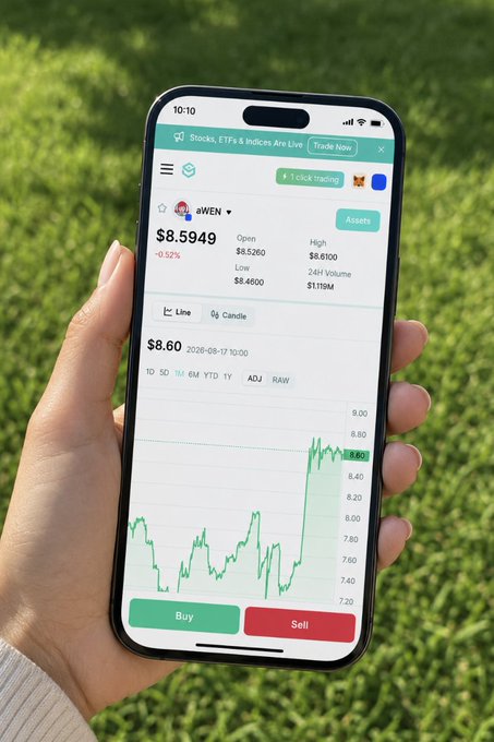 A hand holds a smartphone displaying a stock trading app with ticker $WEN at $8.5949 (down 0.52%), showing a line chart of its price action—capturing the perfect blend of "trading" while literally "touching grass" in the background.