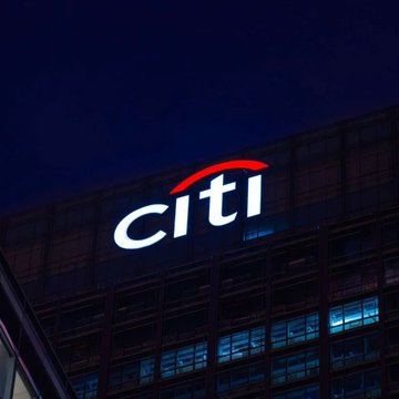 The image shows a tall building at night with a lit sign that reads "Citi" above its entrance. The building appears to be a bank or financial institution, as indicated by the presence of the Citi logo. Below the building, there is a text that reads "Just in: @Citi's new Tokenization report highlights Chainlink CCIP as the interoperability standard connecting the tokenized global financial system." This suggests that the image might have been taken during an event or gathering related to cryptocurrency and blockchain technology at Citi Bank. The focus on this particular aspect of the building indicates its importance in the context of the post's content, which is about the potential growth of tokenized asset markets by 2040 and the role of Chainlink CCIP as a critical interoperability standard for this development.