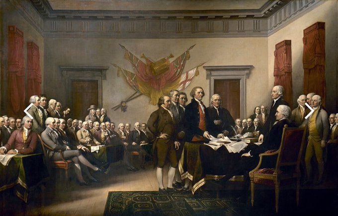 A classical painting depicting a formal gathering of men in 18th-century colonial attire, with five figures standing at the center presenting a document to a seated official, likely representing the signing of the Declaration of Independence.