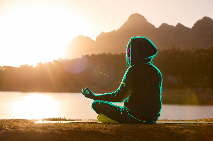 A silhouette of a person sitting cross-legged in a meditative pose at sunset by a lake with mountains in the background. The outfit features a glowing neon outline, reflecting the calm, focused mindset of the person preparing for a major mint on the Robinhood chain.