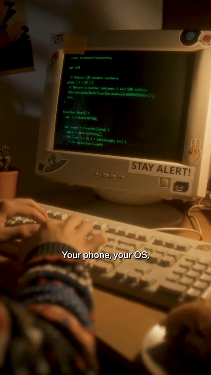 A young person types code on an old CRT monitor displaying JavaScript with random number generation, accompanied by a "STAY ALERT!" sticker, while subtitles read "Your phone, your OS,". The retro hacking setup visually reinforces the post's message that static security is a "countdown," highlighting Ledger's Donjon team as active defenders against constantly evolving threats.