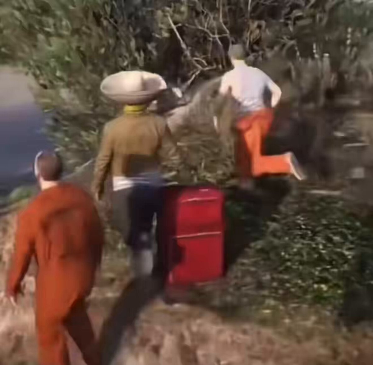 The image shows a group of people standing around, with one person wearing an orange jumpsuit holding a red suitcase while another person has a hat on their head. The background features trees and bushes, suggesting that they are in a natural setting or park. There is also text visible in the image, which reads "community members after minting the NFT".