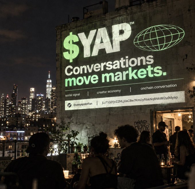 A nighttime urban scene featuring a large illuminated billboard reading '$YAP Conversations move markets.' with hashtags like #social signal, #creator economy, and #onchain conversation, overlooking a rooftop gathering.
