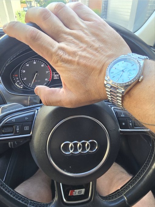 A hand rests on the steering wheel of an Audi S6, displaying a silver wristwatch with a blue dial. The post plays on "S6" — referring to both the car model and a type of dessert ("pie"), tying into the ticker $PIE and the mention of collecting cookies.