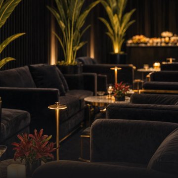 Dark, upscale lounge seating area with plush black velvet sofas, warm lighting, and tropical greenery creates an exclusive ambiance fitting for the premium ether.fi Cardholder experience at Token2049. The intimate setting visually reinforces the post's promise of a refined networking space for members.