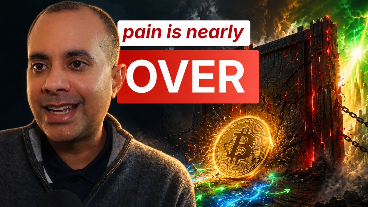 The image shows a man with short dark hair wearing a gray sweater, smiling at the camera against a dramatic background featuring a cracked fortress-like wall with chains, green lightning, and a glowing golden Bitcoin coin. Bold text overlays read "pain is nearly OVER," which ties into the post's discussion about bitcoin breaking out of its downtrend and the bearish $45,000 scenario becoming less likely.