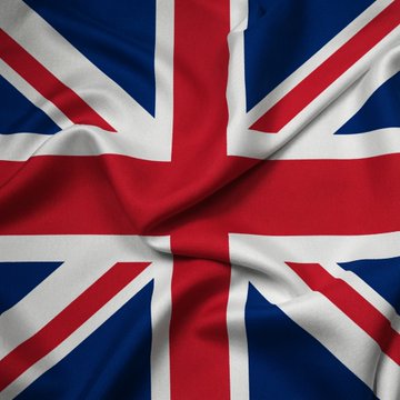 A close-up photograph of a waving United Kingdom (Union Jack) flag showing its red, white, and blue pattern with fabric folds and creases.