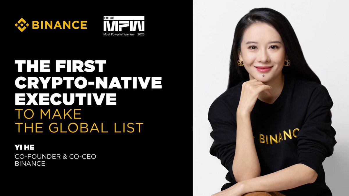 The image features a woman sitting down and smiling at the camera while wearing a black sweater. The background of the image is white, which makes her face stand out. In front of her, there's text that reads "History made: Yi He, Co-CEO & Co-Founder of #Binance, has become the first crypto-native executive ever named to Fortune's Most Powerful Women in Business 2026 list". The woman appears to be a successful businesswoman who is making waves in the world of cryptocurrency.