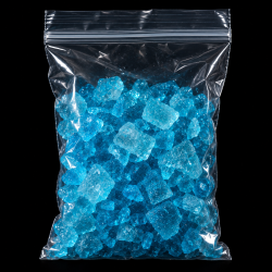 A clear plastic ziplock bag filled with bright blue crystalline chunks against a black background.