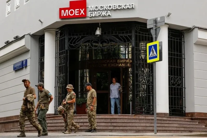 Armed men in military-style clothing stand outside the Moscow Exchange building (МОСКОВСКАЯ БИРЖА / MOEX).