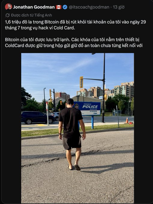 A screenshot of a Twitter/X post by Jonathan Goodman (@itscoachgoodman) in Vietnamese discussing a Bitcoin hack involving ColdCard, with a photo of him walking toward a Mississauga Police station.