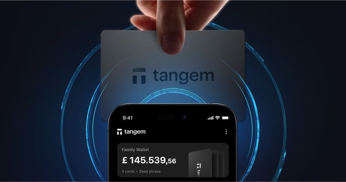 A promotional image for Tangem showing a hand holding a Tangem card above a smartphone displaying the app with a balance of £145,539.56.