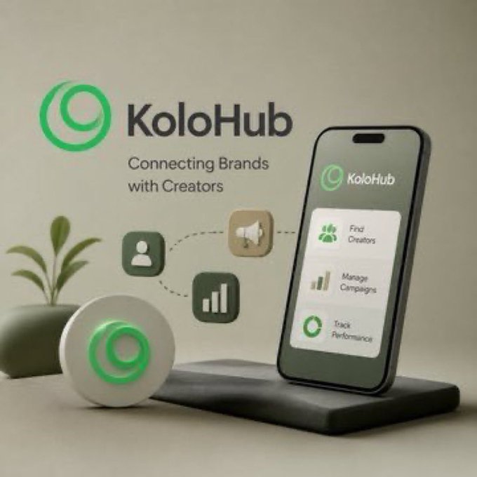 The image features a cell phone with an app called "KoloHub" displayed on its screen. The app appears to be related to cryptocurrency or finance, as indicated by the text that reads "The next evolution of finance is already happening @KoloHub is helping connect crypto with real-world utility instead of keeping it locked inside exchanges and wallets". 

In addition to the cell phone, there are two potted plants in the image. One plant is located on the left side of the frame, while the other is situated towards the right side. The background of the image consists of a gray surface with some text visible at the top that reads "Focus on what is in the image and how it relates to the post".