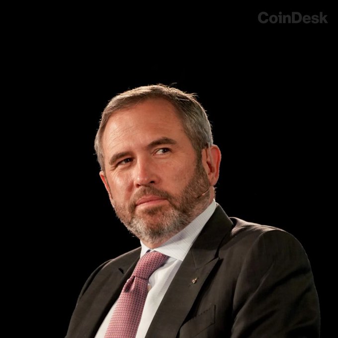 The image features a man wearing a suit, tie, and looking off into the distance with a serious expression. The caption reads "INSIGHT: I've been in crypto long enough to know when a moment is real." This suggests that the man might be knowledgeable about cryptocurrency or has experienced significant events related to it. 

The image also includes text that says "CoinDesk" and "Ripple's Swell conference returning to New York this fall," which indicates that the photo was taken at an event related to cryptocurrency, possibly a conference or exhibition. The man in the suit appears to be interested in what is being said about Ripple's Swell conference, as he looks into the distance with a serious expression.
