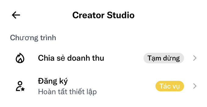 A Vietnamese Creator Studio screen showing 'Chia sẻ doanh thu' (Revenue Sharing) is paused (Tạm dừng) and 'Đăng ký' (Sign up) needs to be completed (Hoàn tất thiết lập).