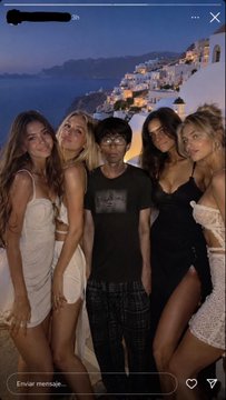 An Instagram Story screenshot shows a group of five people posing together at night with a lit-up town in the background.