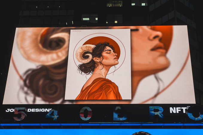A large digital billboard displays an artistic illustration of a woman with ram horns, with the text 'NFT' visible on the screen below.