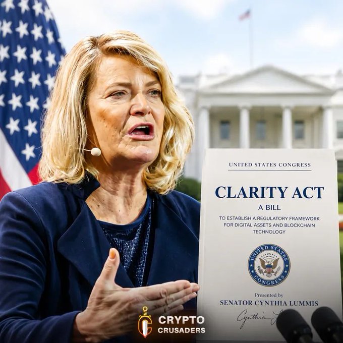 The image features a woman, presumably a politician or public figure, standing next to an American flag while holding up a piece of paper with the title "Clarity Act" written on it. The text in the image reads, "We don't care about Politics. Pass the Clarity Act." This suggests that she is advocating for clarity and transparency in political matters, which could be related to the bill being discussed or signed into law.