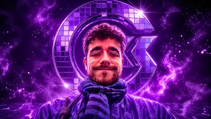 A young man with a beard smiles while wearing a purple jacket and scarf, standing in front of a purple disco ball with the letter 'G' set against a cosmic purple background.