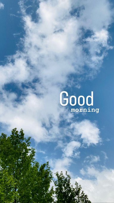 The image features a beautiful blue sky filled with white clouds against a green tree background. The caption of the image reads "Good Morning" along with some text about a morning lineup, which includes @NomismaNetwork and @useTria.