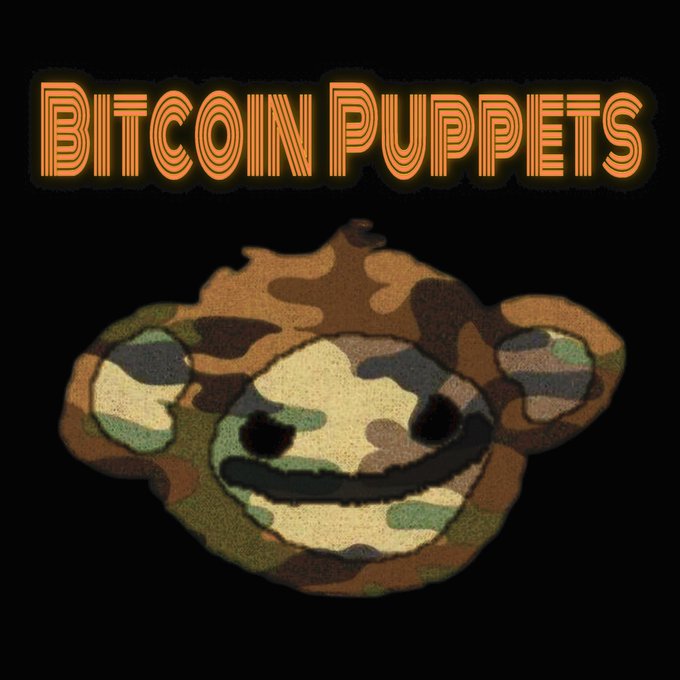 A cartoon monkey face with camouflage pattern and a mischievous grin, with the text "BITCOIN PUPPETS" in orange neon-style lettering above it.