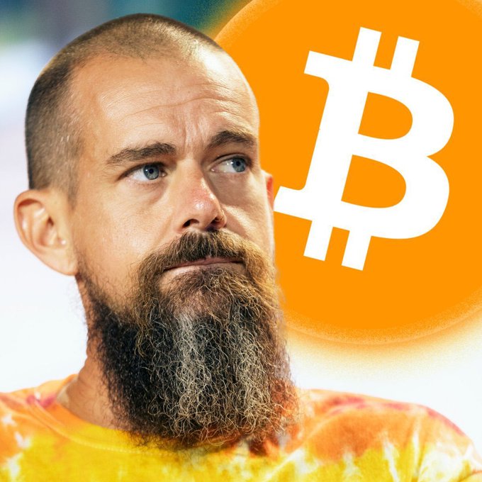 A man with a long beard in a tie-dye shirt is pictured next to a large Bitcoin logo, suggesting a connection to cryptocurrency.
