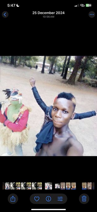 The image shows two people posing for a photo, with one person wearing a mask and holding a bird while another person poses without any mask or costume. The background of the photo features trees and a park setting. The caption of the image reads "This is me before and after I became a @doginaldogs #letmesee yours!!!".