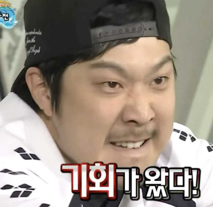 A man wearing a backwards black cap and white shirt grimaces intensely, with Korean text "기화가왔다!" (roughly "The timing has come!") overlaid, humorously conveying the excitement and thrill of catching a sudden coin price spike at the right moment.