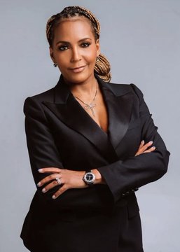 The photo features a confident woman with braided hair, wearing a black blazer, layered gold necklaces, and a watch, with her arms crossed.

The image relates to the post as it likely depicts Keisha Lance Bottoms, one of the candidates mentioned in the breaking news about the Georgia governor race being tied at 50-50 odds.