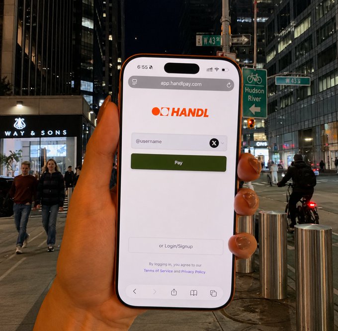 A hand holds up a phone displaying the HANDL payment app at app.handlpay.com, showing a username field with a green "Pay" button, set against a nighttime New York City street scene near W 43rd St and the Hudson River. The image illustrates the concept of using a social media handle as a private payment method, with the app's clean interface emphasizing the simplicity of the username-based transaction process described in the post.