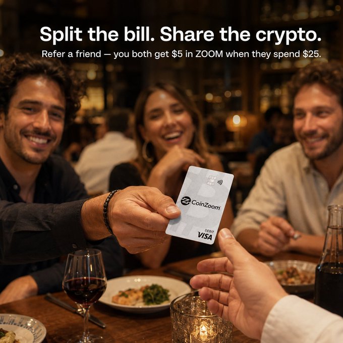 An advertisement showing three smiling friends at a dinner table with the text 'Split the bill. Share the crypto. Refer a friend — you both get $5 in ZOOM when they spend $25,' featuring a hand holding out a 'CoinZoom' Visa debit card.