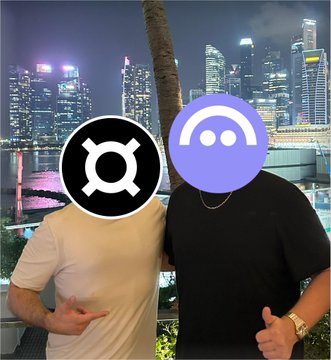 The image features two men posing for a picture with their faces obscured by stickers of logos or symbols. One man has a sticker that reads "Oculus" while the other has a sticker that says "LlamaRisk". The background shows a cityscape at night, and there is text in the image that references stablecoins like frxUSD and lending hubs such as Aave V4.