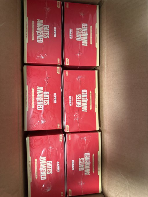 A cardboard box containing six red boxes labeled 'GATES AWAKENED' by ASMODUS, appearing to be e-liquid/vape products.