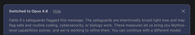 The image shows a system notification indicating the user has been switched to "Opus 4.8" after Fable 5's safeguards flagged their message, noting the measures are intentionally broad and may flag routine coding, cybersecurity, or biology work. This relates to the post where the user was flagged after asking Fable to open a long position on $ETH, humorously complaining about being put on a "watchlist" for a routine trading request.