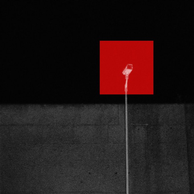 A minimalist graphic shows a white candle or stick extending from the bottom, set against a dark textured background with a bright red square above.