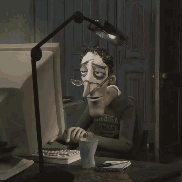 A gaunt, weary-looking man in a "Michigan State" shirt stares at an old computer monitor under a desk lamp, appearing exhausted and overworked. The image humorously captures the tone of a "humbling PR correction" post, depicting the exhausted intern forced to rewrite his awkwardly-worded message about Kaspa's decentralized network.
