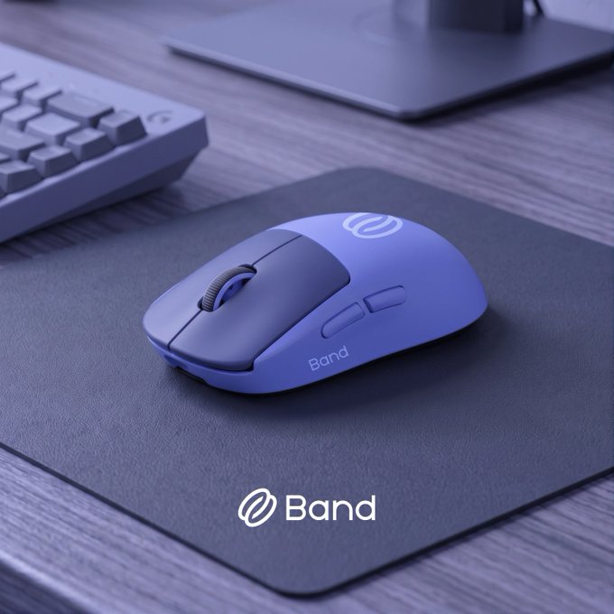 A purple wireless gaming mouse branded 'Band' rests on a black mousepad next to a mechanical keyboard.