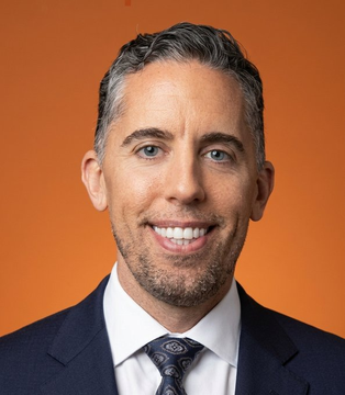 The image features a man smiling and wearing a suit with a tie. The caption at the bottom of the photo reads "LATEST: Strive has acquired 73 Bitcoin for approximately $4.7 million, according to Strive CEO Matt Cole." This information is likely related to the fact that the man in the picture appears to be happy or proud, which could indicate he's involved with a new and potentially successful venture, such as cryptocurrency. The image does not provide any additional context about his suit or tie.